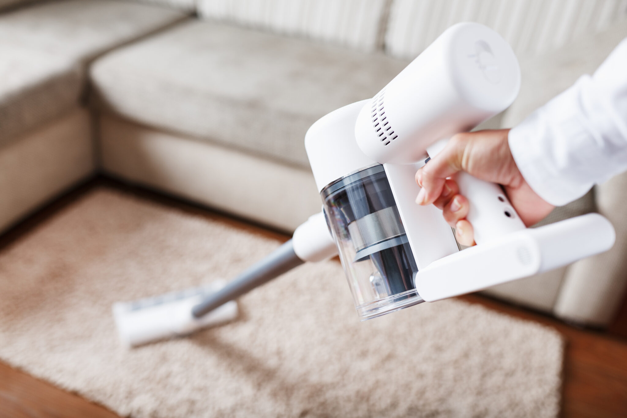 The turbo brush of a cordless vacuum cleaner cleans the carpet in the house in close-up. Modern technologies for cleaning.