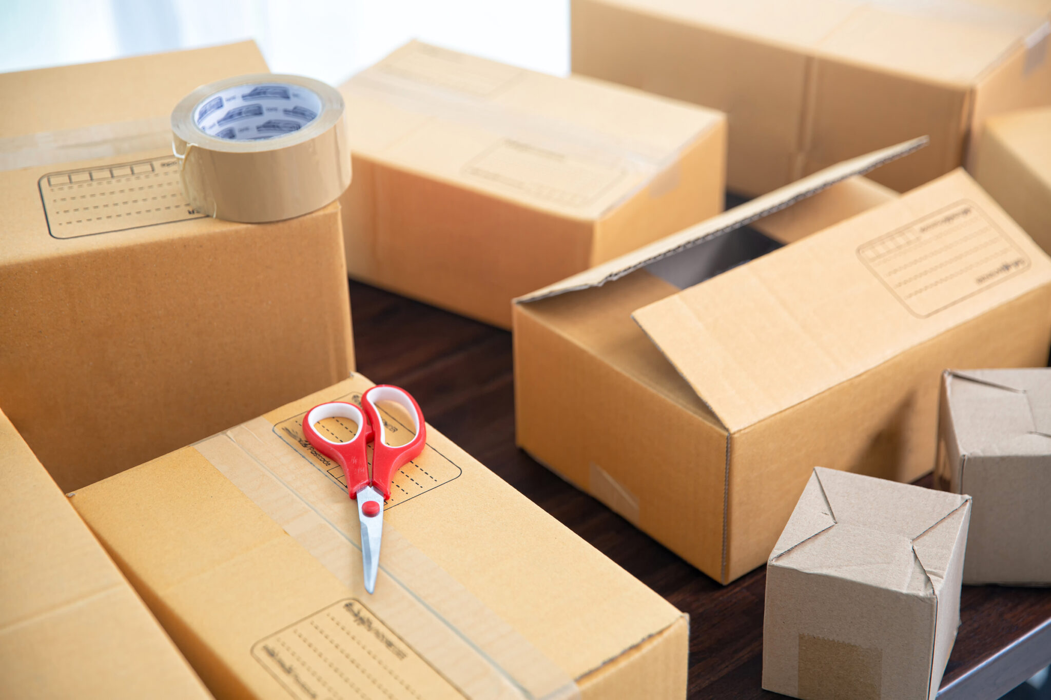 Cardboard parcel boxes on wooden table. Online selling, e-commerce, packing concept, Morning light